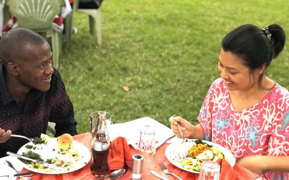 Oga Chan smiling and talking with a guest over lunch outdoors